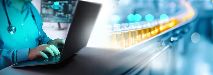 A healthcare professional in a lab coat types on a laptop