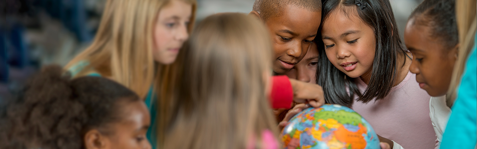 A group of children looking at a globe